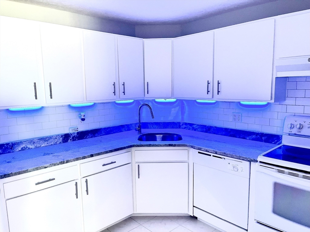 44 Lexington Avenue, Unit 4 Gloucester, MA 01930 - Photo 6 of 11 a kitchen with stainless steel appliances white cabinets granite counter tops and a stove