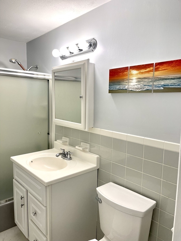 44 Lexington Avenue, Unit 4 Gloucester, MA 01930 - Photo 10 of 11 a bathroom with a sink mirror vanity and toilet