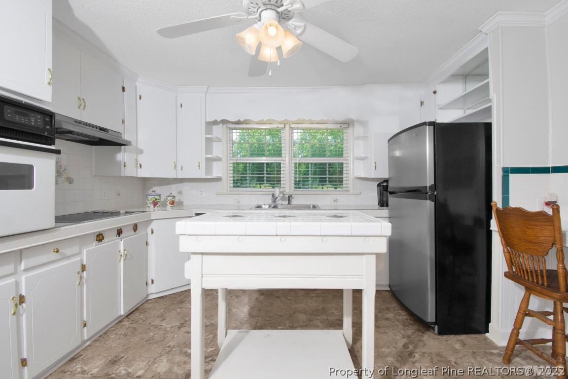 1541 3 Bridge Road Dunn, NC 28334 - Photo 14 of 32 a kitchen with stainless steel appliances a stove a sink and a refrigerator