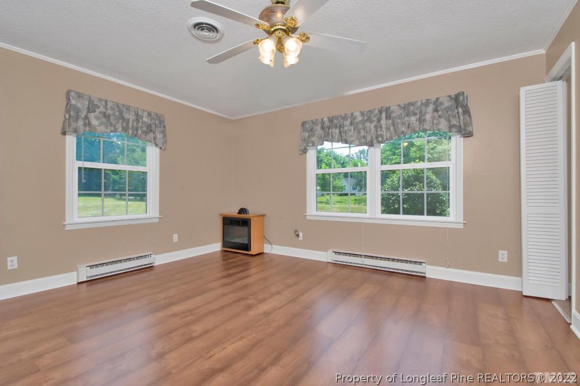 1541 3 Bridge Road Dunn, NC 28334 - Photo 22 of 32 a view of an empty room with a window and wooden floor