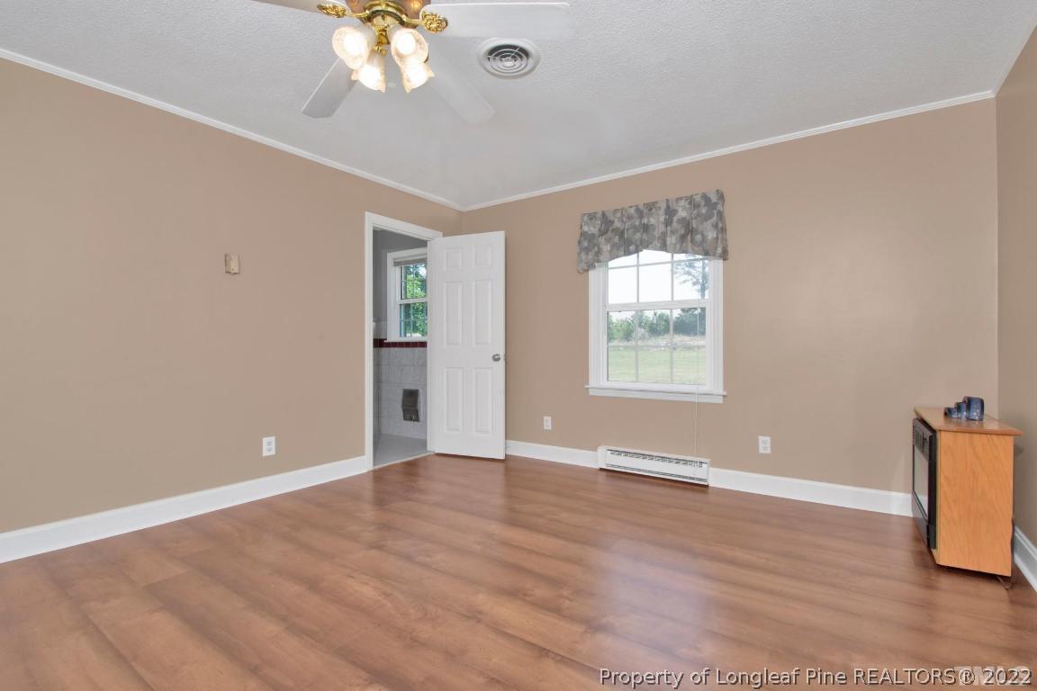 1541 3 Bridge Road Dunn, NC 28334 - Photo 23 of 32 a view of an empty room with wooden floor and a window