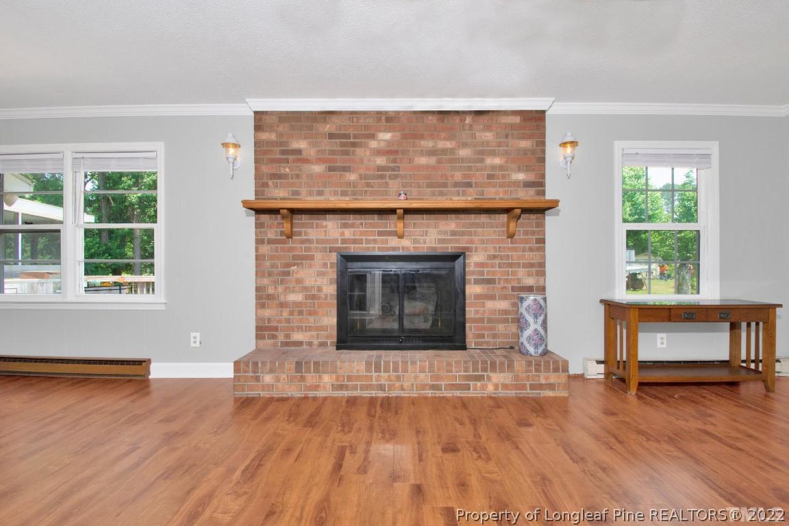 1541 3 Bridge Road Dunn, NC 28334 - Photo 10 of 32 a living room with a fireplace and wooden floor