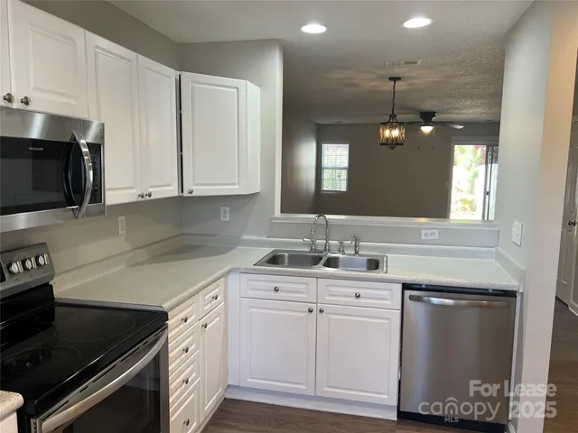 a kitchen with a sink stove and cabinets