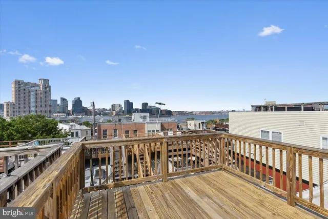 a view of a balcony with wooden floor and fence