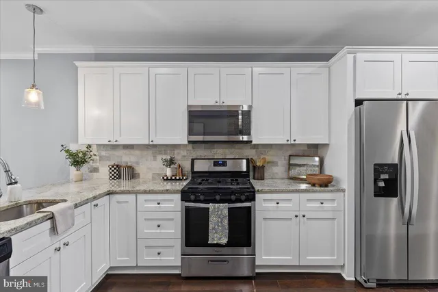 a kitchen with white cabinets and stainless steel appliances