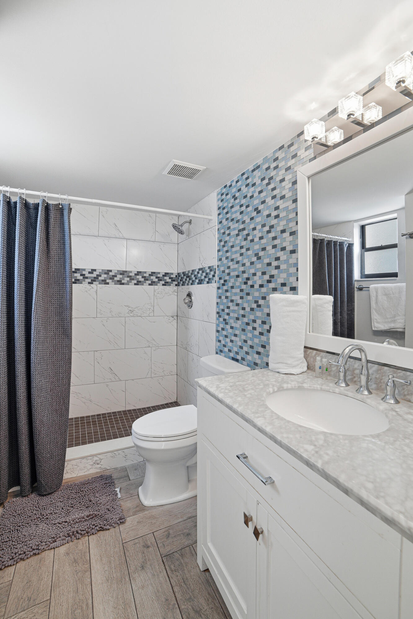 105 Deer Creek Road Deerfield Beach, FL 33442 - Photo 6 of 18 a bathroom with a granite countertop sink a toilet a mirror and shower