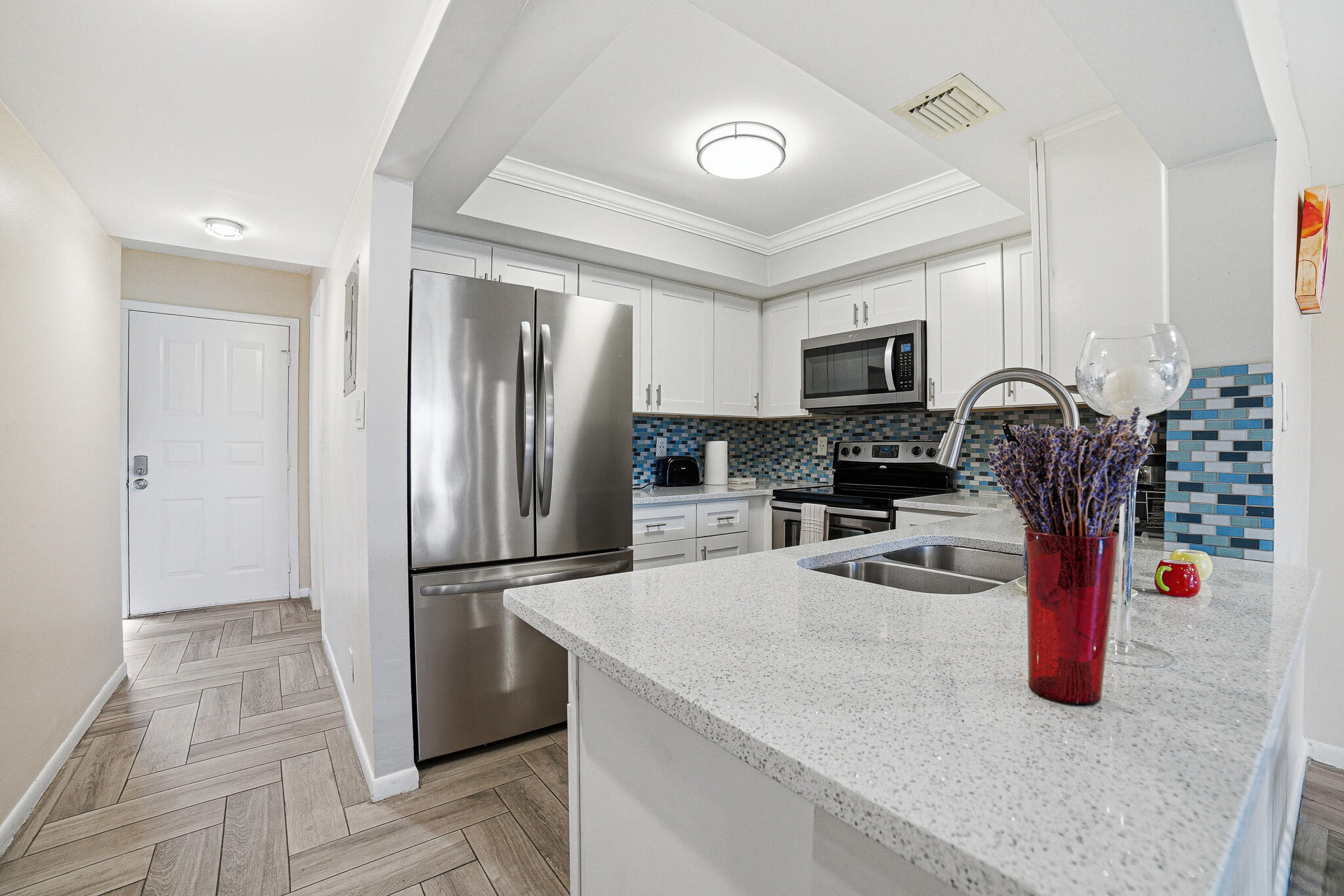 105 Deer Creek Road Deerfield Beach, FL 33442 - Photo 7 of 18 a kitchen with stainless steel appliances granite countertop a refrigerator and a stove