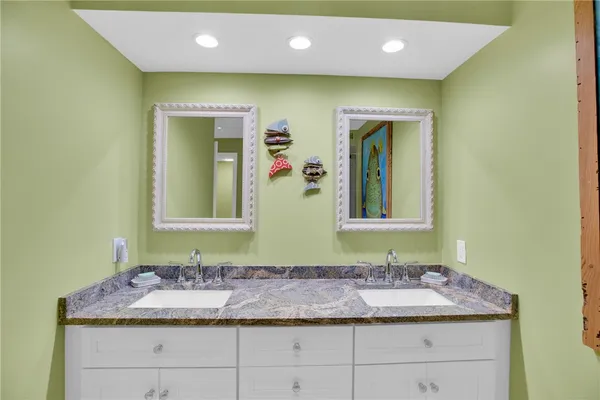 a bathroom with a granite countertop sink and a mirror