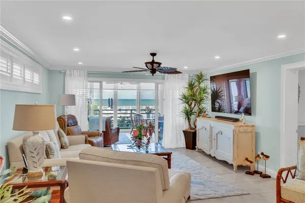 a living room with furniture a flat screen tv and a large window
