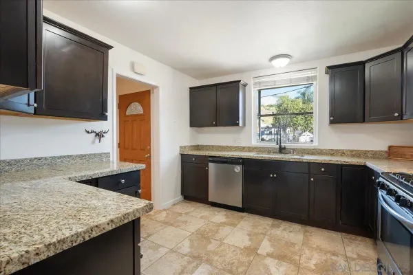 a kitchen with stainless steel appliances granite countertop a refrigerator stove and sink