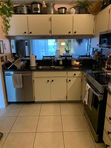 a kitchen with stainless steel appliances granite countertop a sink a stove a microwave and cabinets