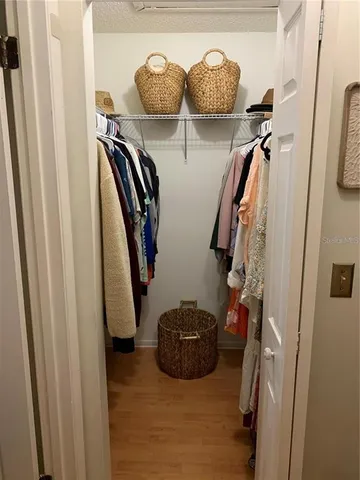 a view of walk in closet with clothes and shoes
