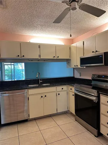 a kitchen with granite countertop a sink and a stove