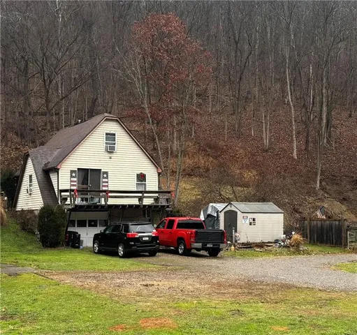 a view of a house with cars parked in front of house