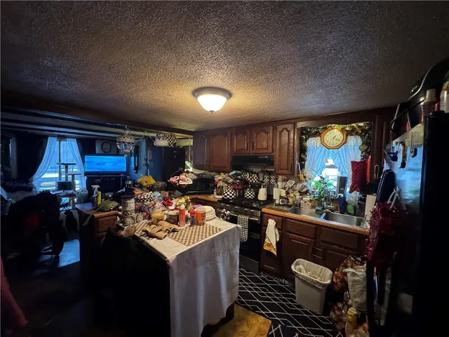a kitchen filled with a stove a refrigerator and a dining table with wooden floor