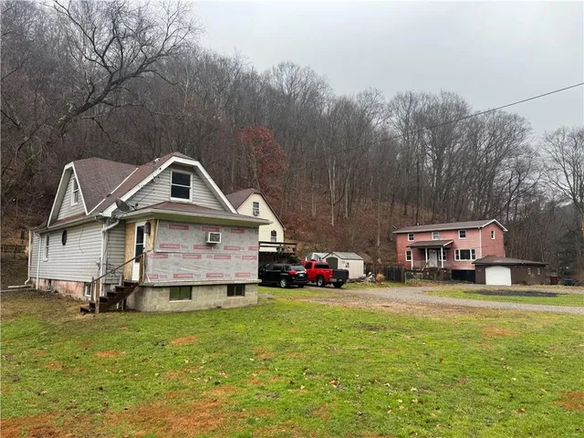 a car parked in front of house with a big yard