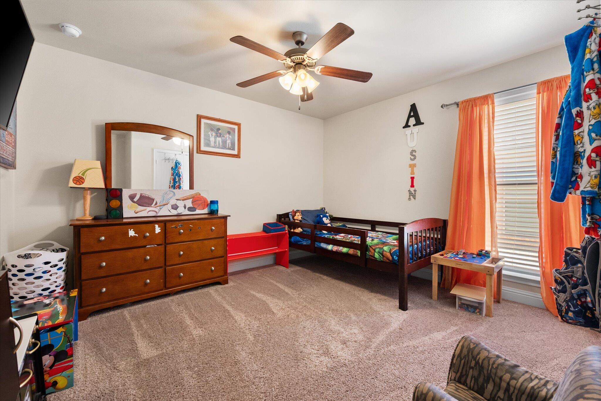 7038 95th Street Lubbock, TX 79424 - Photo 17 of 23 a bedroom with furniture and a lounge chair
