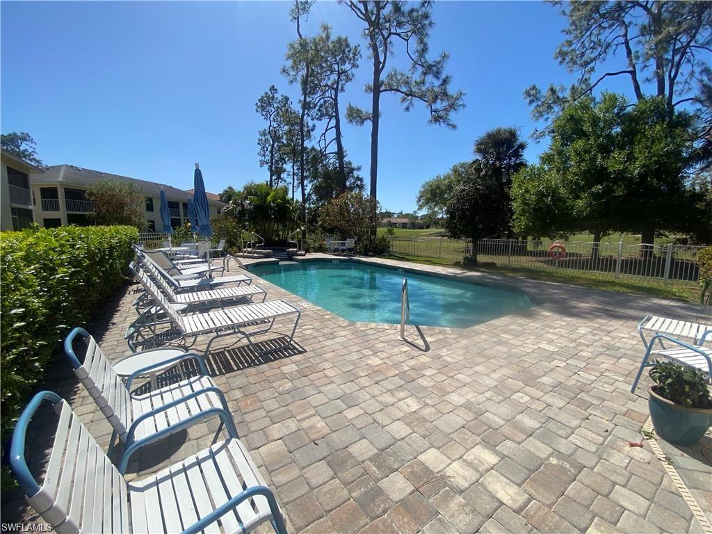 705 Augusta Boulevard, Unit 7055 Naples, FL 34113 - Photo 16 of 18 a view of a patio with table and chairs and potted plants