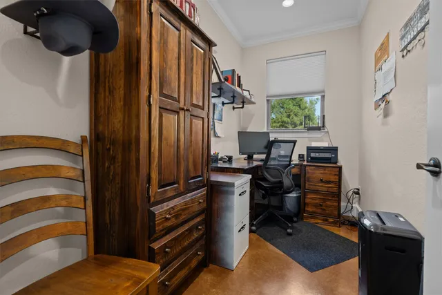 a view of a workspace with furniture and a window