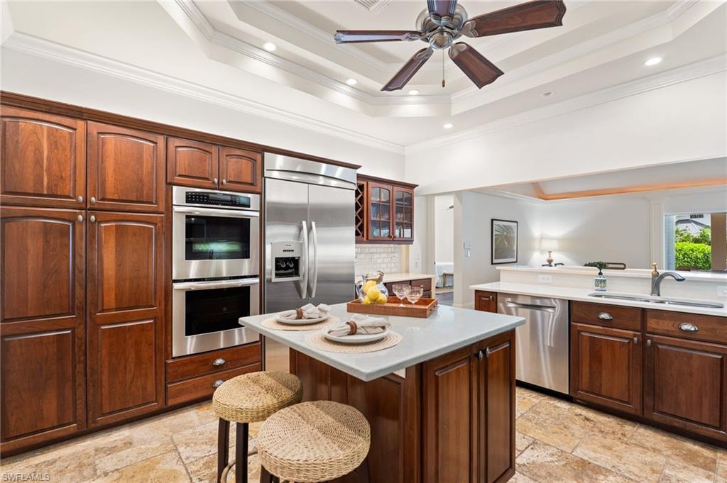 2201 Beacon Lane Naples, FL 34103 - Photo 12 of 25 a kitchen with a refrigerator a sink and chairs