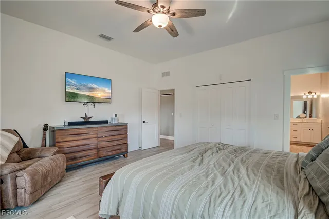 a bedroom with a bed a large window and a chandelier