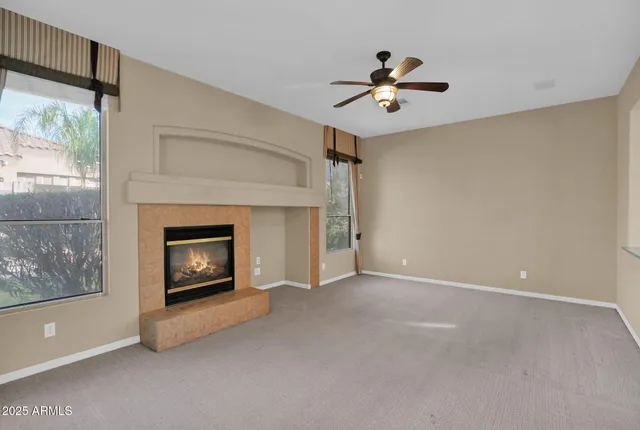 a view of an empty room with a fireplace and a window