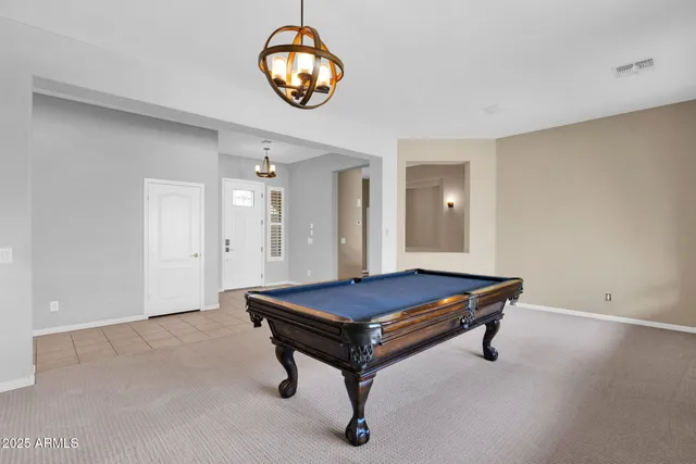 a room with pool table and chandelier