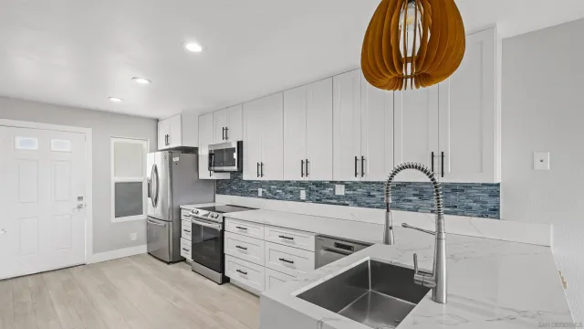 a kitchen with stainless steel appliances a stove a sink and a cabinets