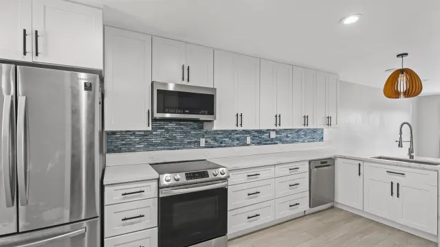 a kitchen with white cabinets and stainless steel appliances