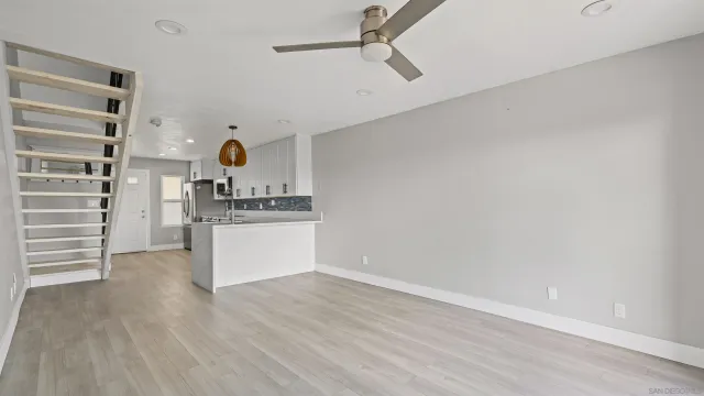 a view of a kitchen with wooden floor and electronic appliances