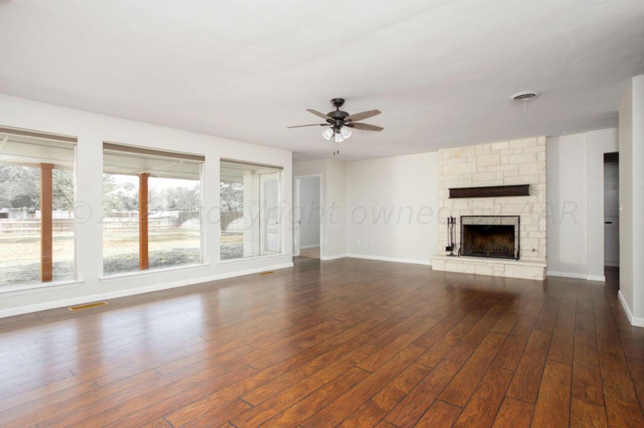 4818 Arden Road Amarillo, TX 79110 - Photo 6 of 29 a view of an empty room with a window and wooden floor