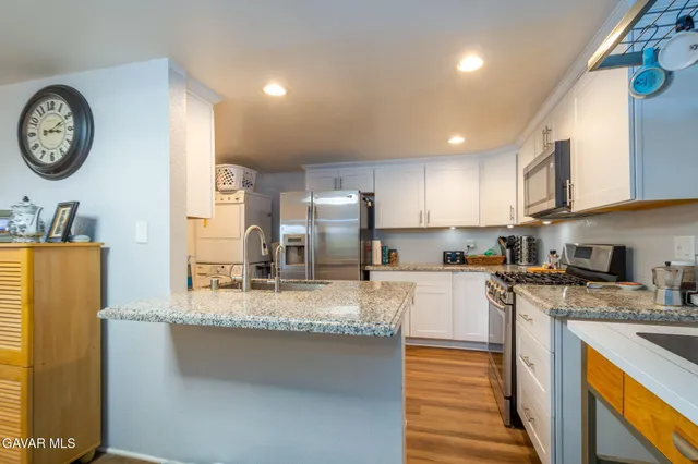 a kitchen with stainless steel appliances granite countertop a sink a stove and a refrigerator