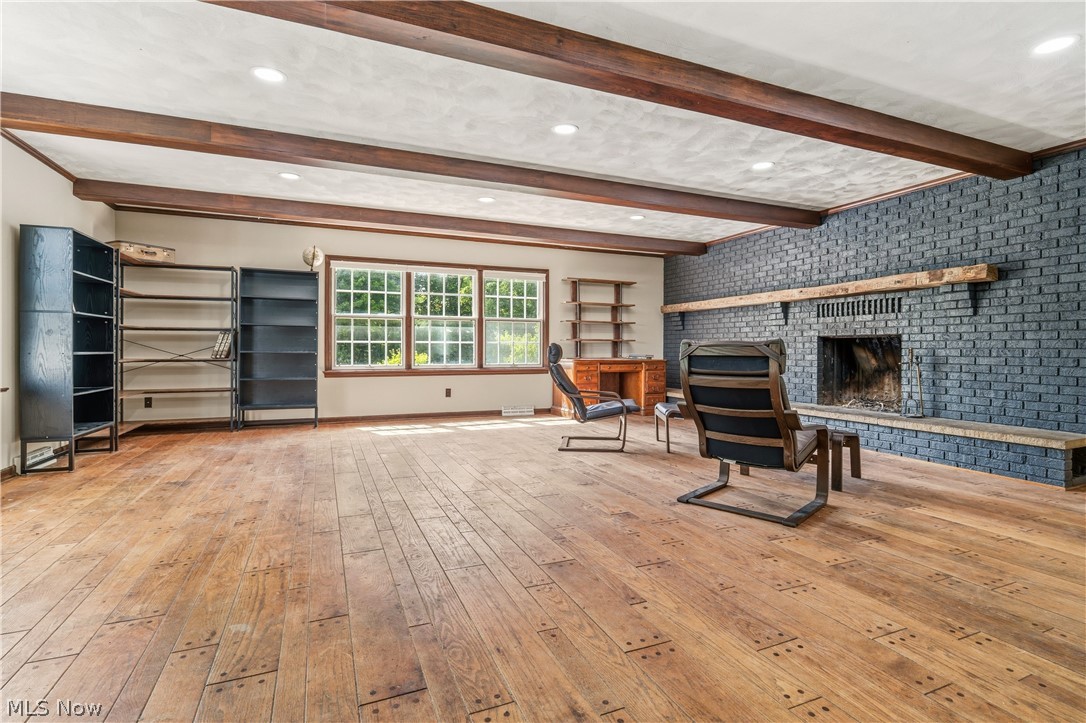 1769 Paradise Road Orrville, OH 44667 - Photo 24 of 36 Spacious living area featuring wood-finish flooring, exposed ceiling beams, recessed lighting, a painted brick fireplace with a wood mantle, and multiple windows