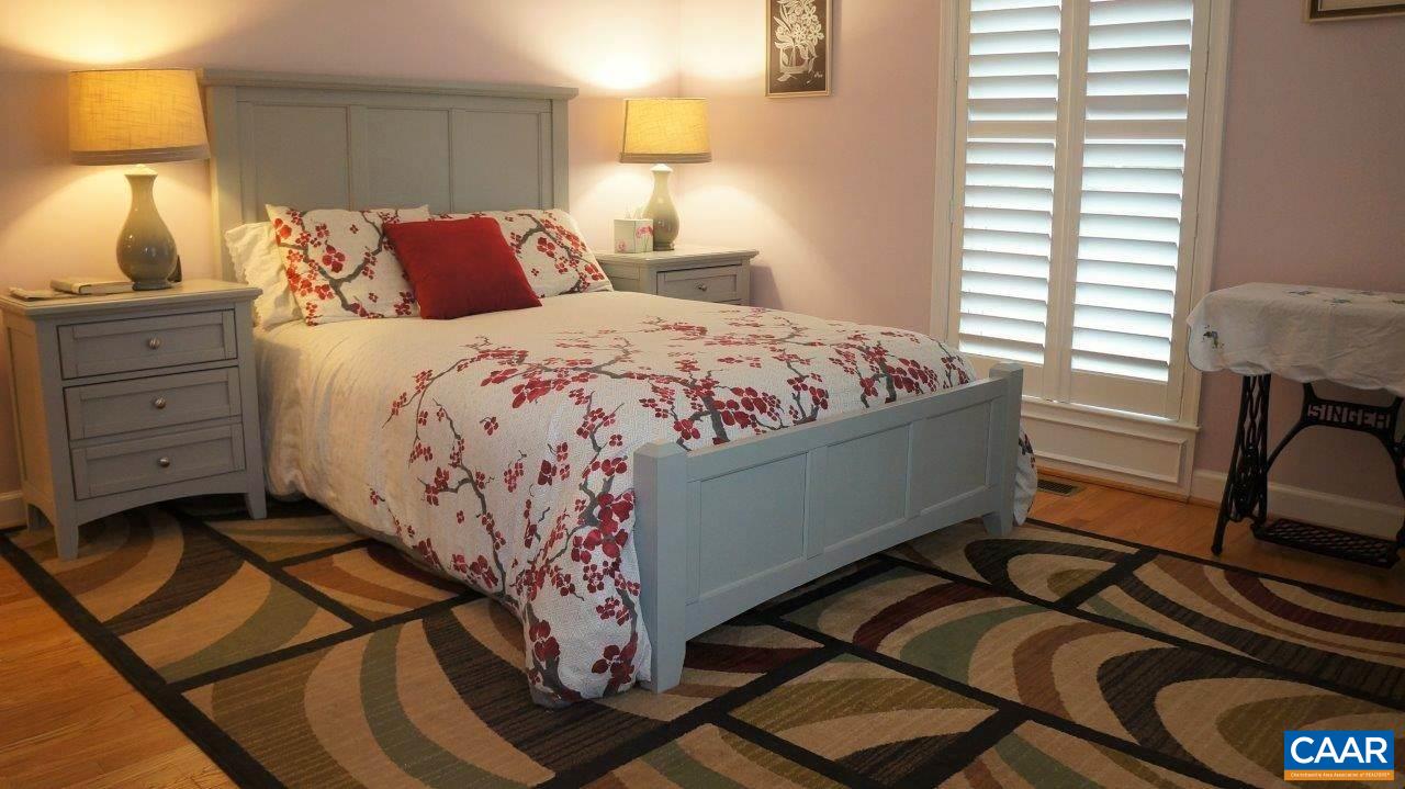 3621 Keswick Road Keswick, VA 22947 - Photo 28 of 50 a bedroom with a bed and wooden floor