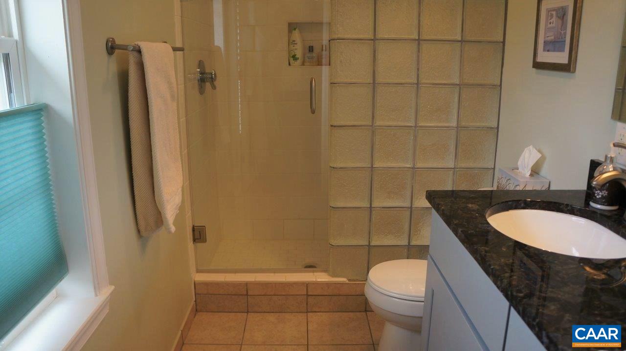 3621 Keswick Road Keswick, VA 22947 - Photo 29 of 50 a bathroom with a granite countertop toilet sink and shower