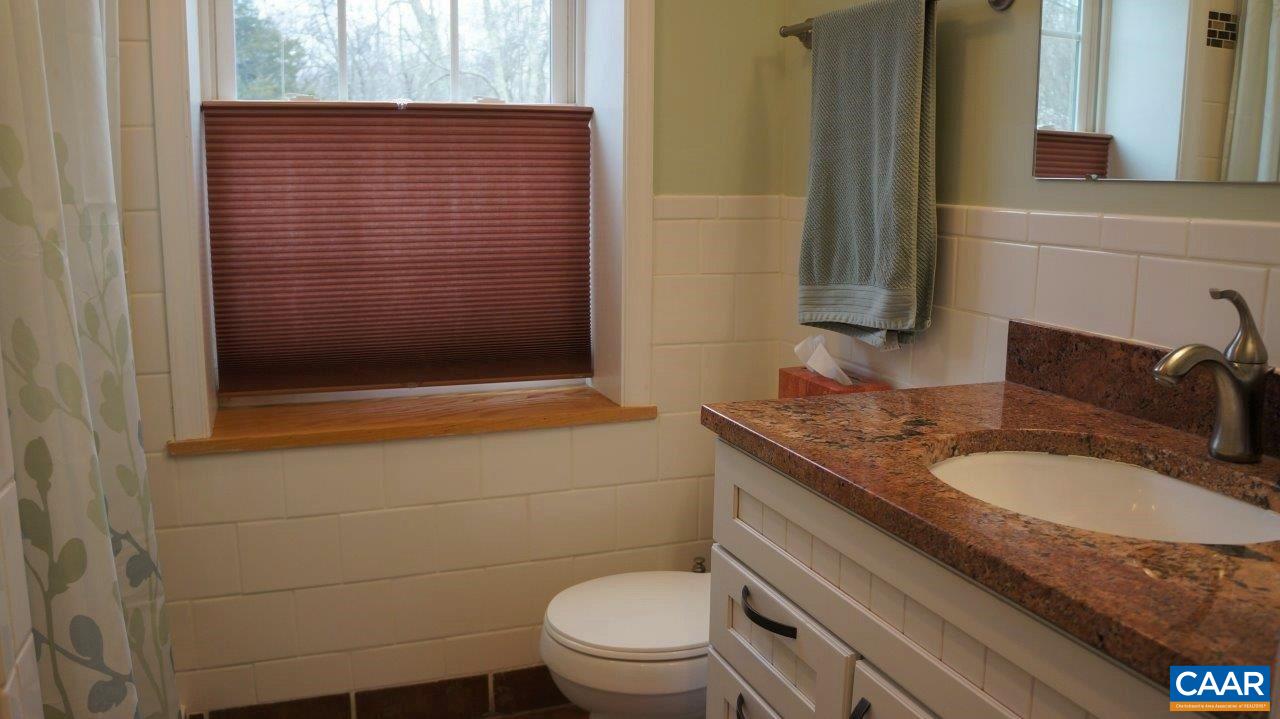 3621 Keswick Road Keswick, VA 22947 - Photo 38 of 50 a bathroom with a granite countertop toilet sink and mirror