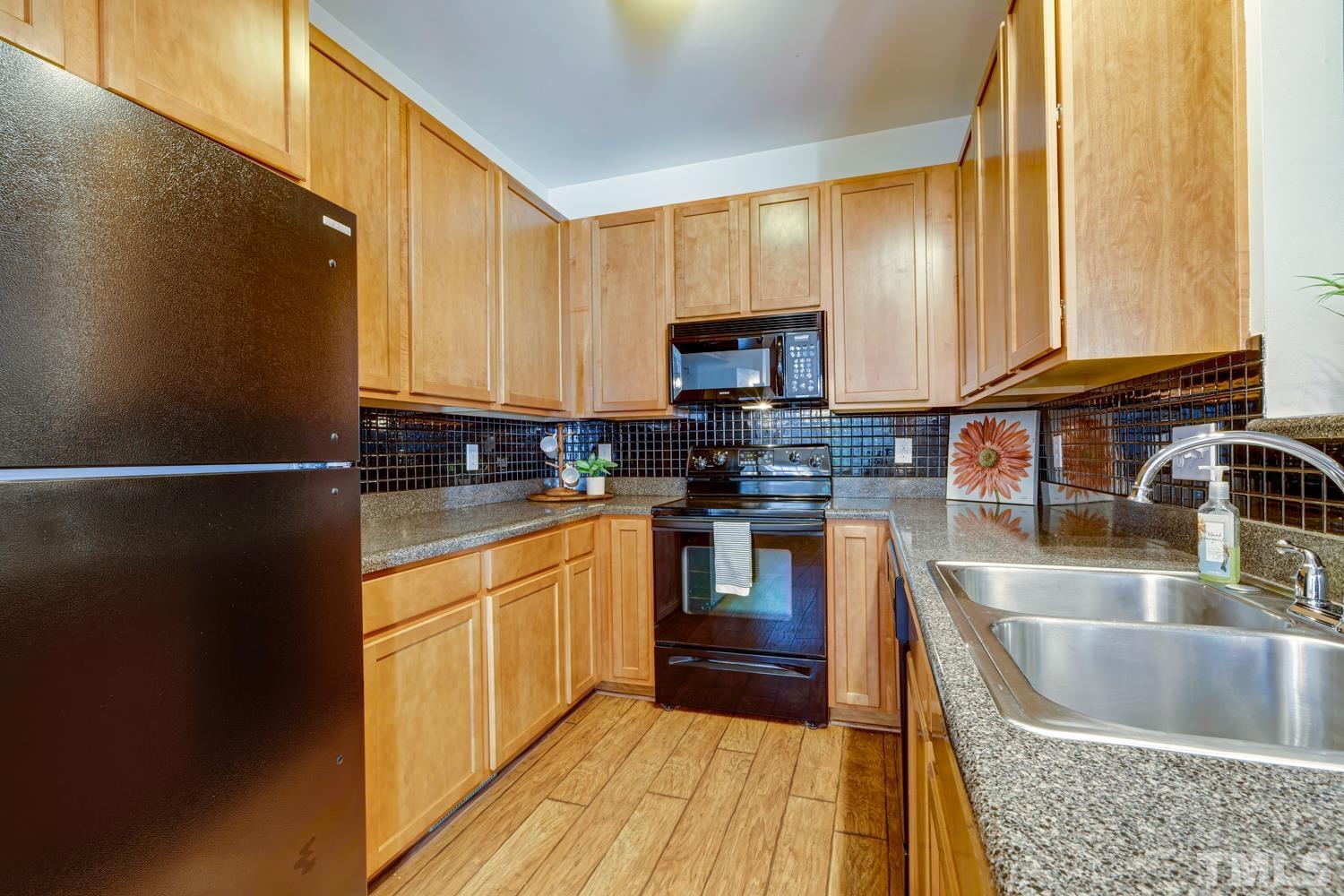 5405 Goldenglow Way Raleigh, NC 27606 - Photo 14 of 30 a kitchen with stainless steel appliances granite countertop a sink stove and microwave