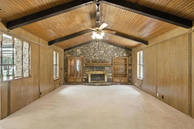 a view of an empty room with a fireplace and a window