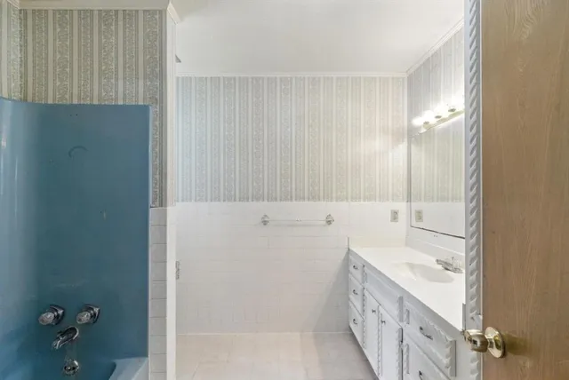 a bathroom with a tub sink and mirror