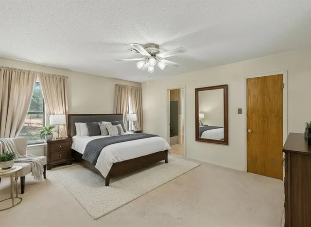 a spacious bedroom with a large bed and a chandelier