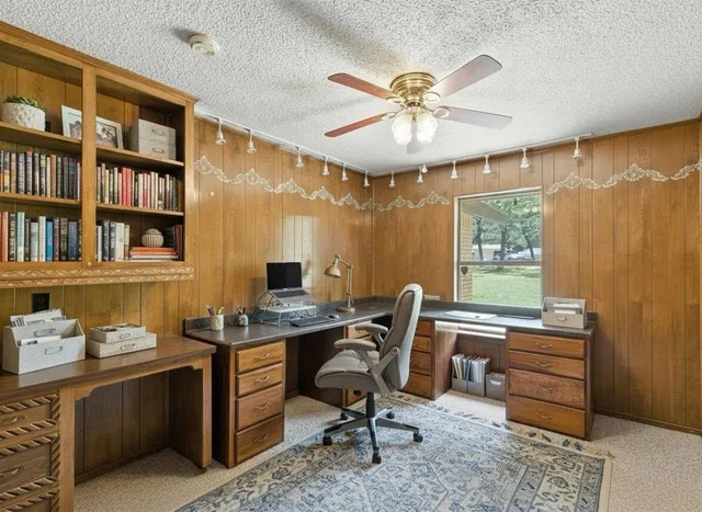 a view of a workspace with furniture and a window