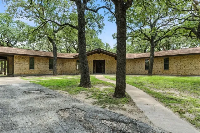a view of a house with a yard and large tree
