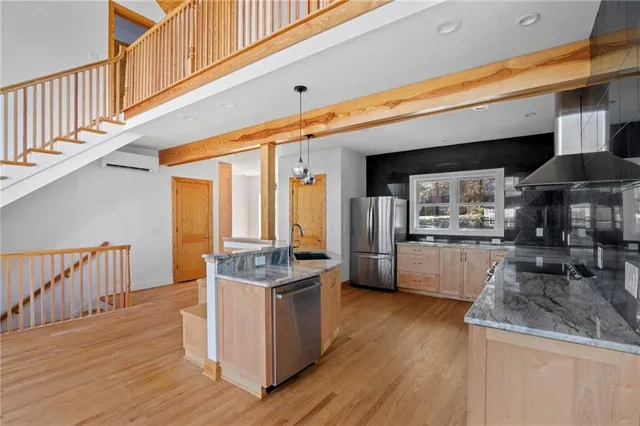 a kitchen with stainless steel appliances granite countertop a stove and a wooden floors