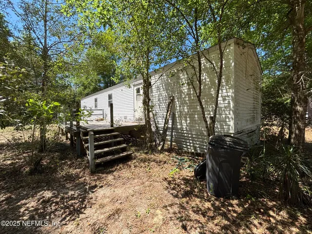 a view of a backyard with large trees