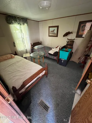 a view of a backyard with large trees and a small barn