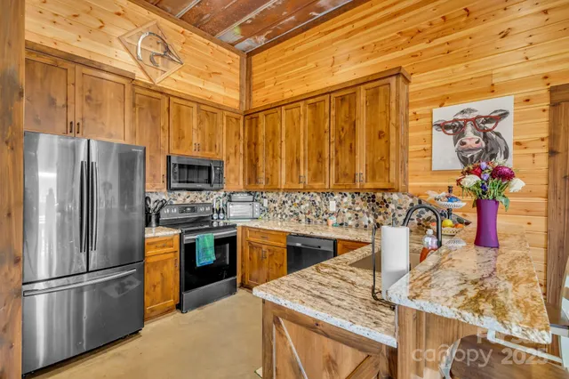 a kitchen with stainless steel appliances granite countertop a refrigerator a stove top oven a sink and dishwasher