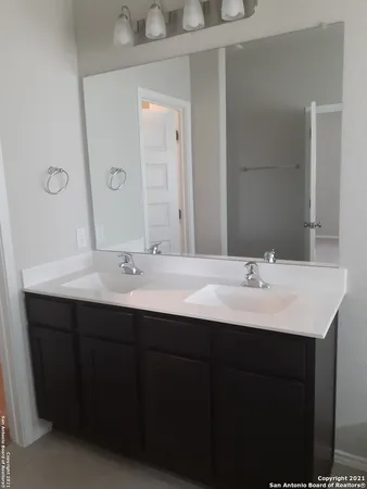 a bathroom with a double vanity sink and a mirror