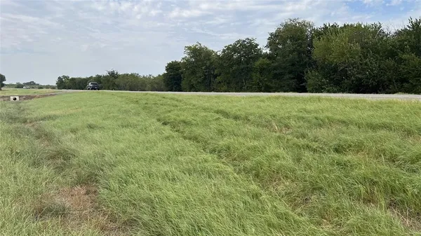 a view of a green field with wooden fence
