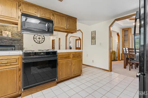 a kitchen with kitchen island granite countertop a refrigerator and a stove