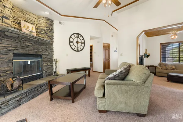 a spacious bedroom with a bed a dresser and a chandelier